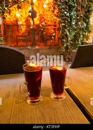 Two glasses of hot mulled wine with lemon in them on a table outside a wine bar in the city of Chester England Stock Photo