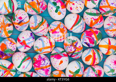 High-angle close-up view of white eggs painted in vivid colors as festive full frame Easter background Stock Photo