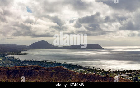 View of the dormant Koko Head Crater, Oahu, Hawaii and Kaihuokapuaa Cape from Diamond Head Crater across a tranquil Pacific Ocean under a cloudy sky Stock Photo