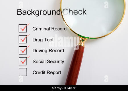 Magnifying Glass Over Background Check Form Stock Photo