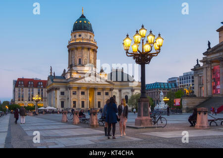 BERLIN, GERMANY - APRIL 30, 2016: French Cathedral on Gendarmenmarkt in evening light. Both visitors and berlin inhabitans enjoy warm Spring evening. Stock Photo
