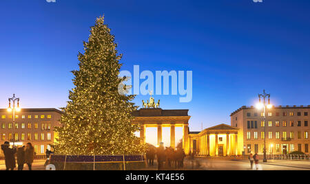 Panoramic image of Brandenburger Gate in Berlin with Christmas tree on a sunset with evening illumination Stock Photo