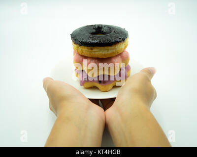 Woman's hand holding donut on white background Stock Photo