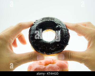 Woman's hand holding donut on white background Stock Photo