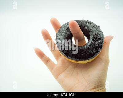 Woman's hand holding donut on white background Stock Photo