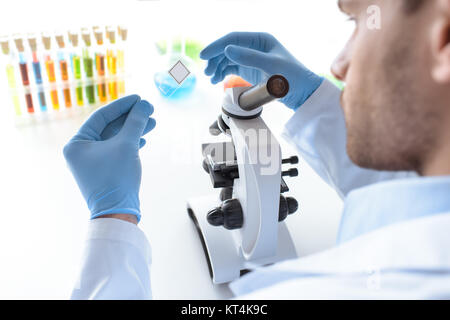 concenrated scientist working with microscope in laboratory Stock Photo