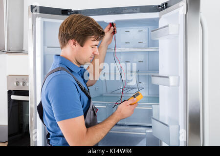 Male Technician Checking Refrigerator Stock Photo