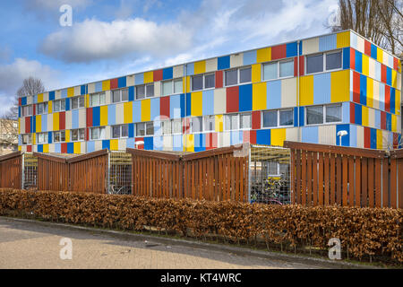 Student housing in shipping containers painted in pright colors with bicycle parking in the foreground Stock Photo