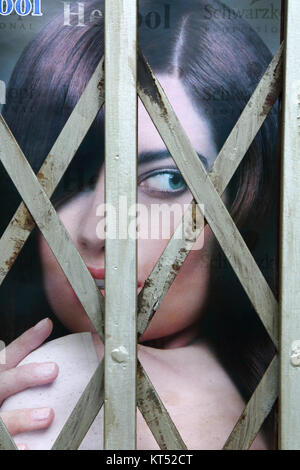 Advertising poster with face of beautiful female model behind security railings on beauty parlour entrance, La Paz, Bolivia Stock Photo