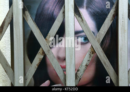 Advertising poster with face of beautiful female model behind security railings on beauty parlour entrance, La Paz, Bolivia Stock Photo