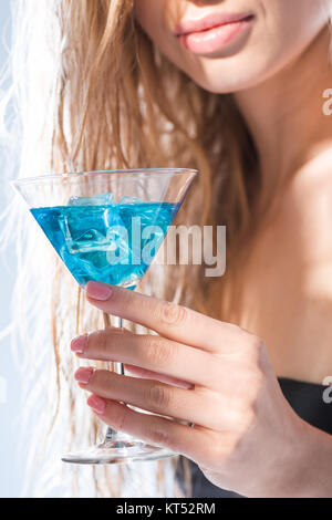 partial close up view of woman holding cocktail drink on white Stock Photo