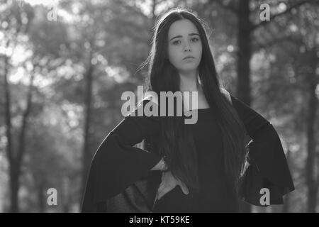 Young woman photographed in a pine forest with a defiant pose Stock Photo