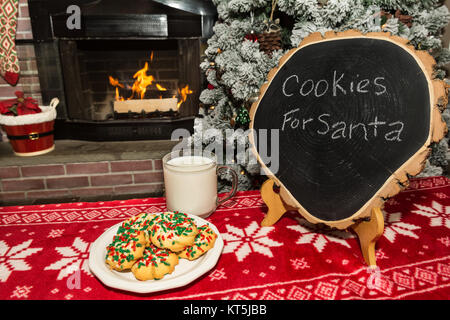 Cookies and milk by the fireplace for Santa on Christmas Eve. Stock Photo