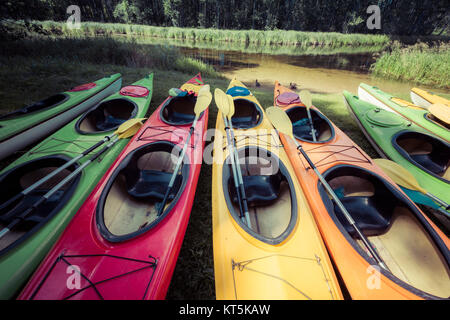 Colorful kayaks moored on lakeshore Stock Photo