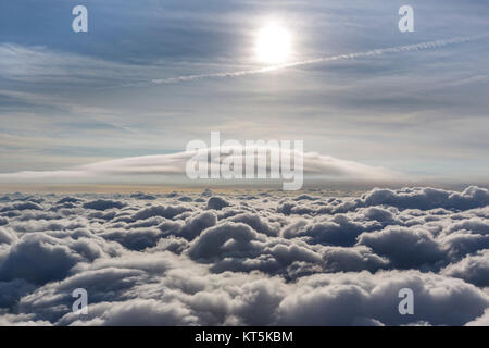 Lenticular cloud above the uppermost cloud layer, cumulus lenticularis, clouds and sun, cloud flight over the northern NRW, clouds and blue sky, difus Stock Photo