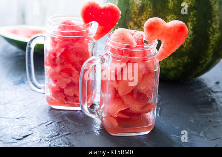 Watermelon in Mason jars decorated with watermelon slices curved like heart symbols Stock Photo