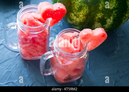 Watermelon in Mason jars decorated with watermelon slices curved like heart symbols Stock Photo