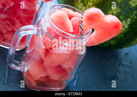 Watermelon in Mason jars decorated with watermelon slices curved like heart symbols Stock Photo