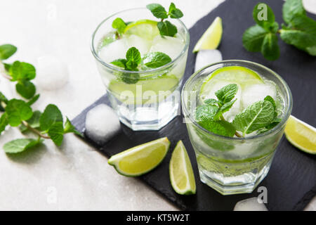 Cold refreshing summer lemonade mojito in a glass on a slate board and stone background. Stock Photo