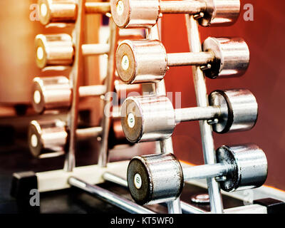 Stand with dumbbells in gym Stock Photo