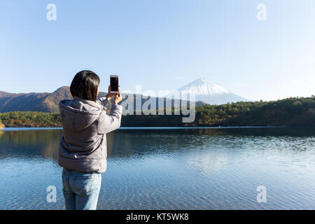 Woman taking picture on Mount Fuji by mobile phone Stock Photo