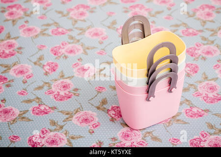 Colorful Small Decorative Plastic Bags with Handle on Flower Pattern Background Stock Photo