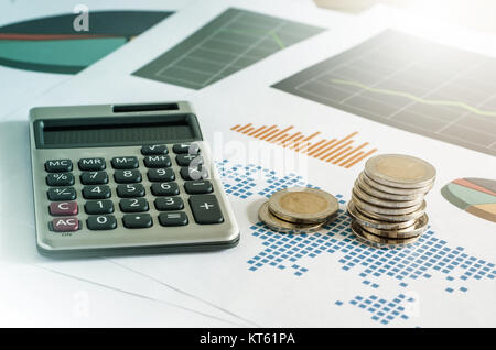 Coin stacks and calculator on paper of financial graph. Business concept. Stock Photo