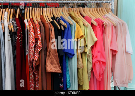 Female clothes on hangers in front of fashion store Stock Photo