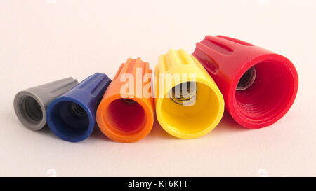 This image shows a variety of twist-on wire connectors, commonly known as wire nuts, in different sizes. These connectors are used in electrical work to join multiple wires securely and safely, providing insulation and protection from electrical hazards. Stock Photo