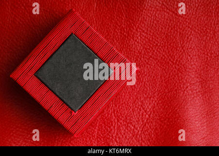 Red black rectangular ring jewellery box on leather background Stock Photo