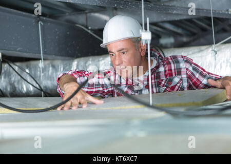 male construction worker in the ceiling Stock Photo