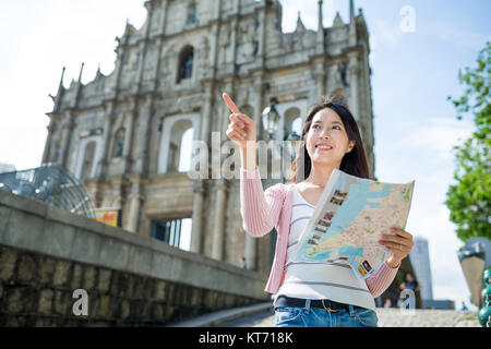 Woman using paper map in Macao city Stock Photo