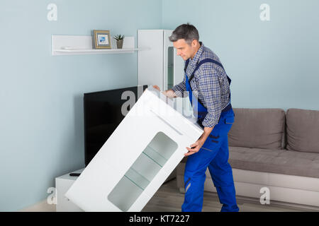Mover Placing Furniture At Home Stock Photo