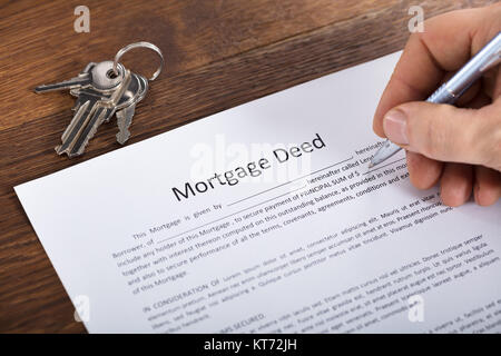 Person Hand Filling A Mortgage Document Stock Photo