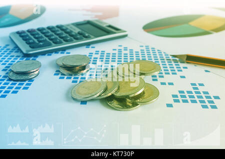 Coin stacks, calculator and pencil on paper of financial graph. Business concept. Stock Photo