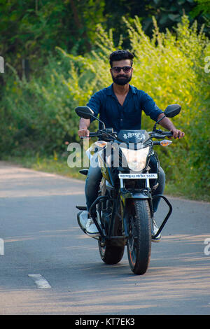 Young man riding bike on road Stock Photo