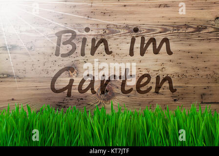 German Text Bin Im Garten Means I Am In The Garden. Spring Season Greeting Card. Sunny Aged Wooden Background With Gras. Stock Photo