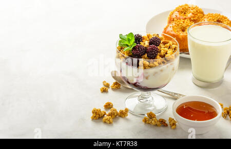 Breakfast of granola, buns brioche, honey and milk . Stock Photo