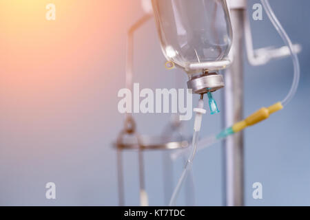 Medical saline iv drip  close up on  light blue background at hospital. Stock Photo