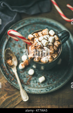 Winter warming sweet drink hot chocolate with marshmallows and cocoa in mug with Christmas holiday candy cane, selective focus Stock Photo