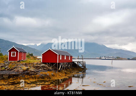 Norwegian hut rorbu on bay coast. Nordic cloudy summer day. Stock Photo