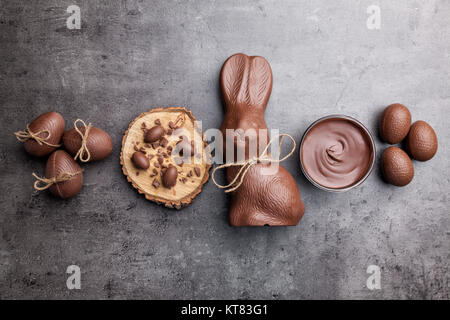 Chocolate Easter bunny and eggs on wooden background Stock Photo