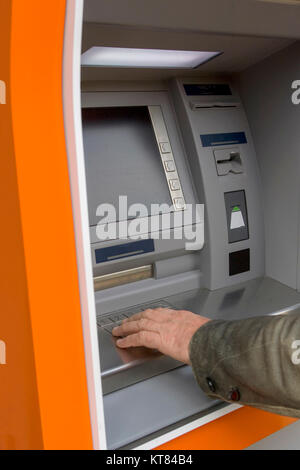 Male hand pushing digits on ATM Stock Photo