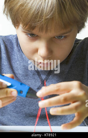 Focused child creating with 3d printing pen. Stock Photo