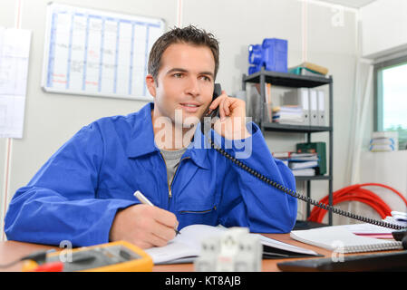 Man in overalls on telephone Stock Photo