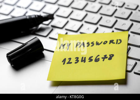 sticky note with weak easy password on laptop keyboard Stock Photo