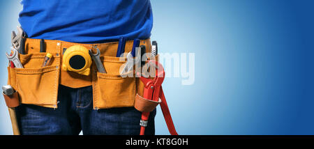 closeup of handyman tool belt on blue background with copy space Stock Photo