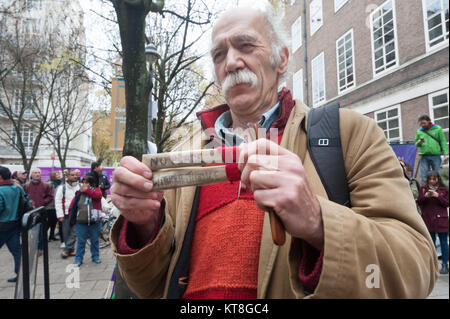 A man poses with a pair of 'clappers' with the message on them 'No Peace Without Justice'. A similar message appears on the reverse in Arabic. Stock Photo