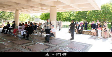 Attendees of the Japanese American Citizens League and the Japanese American Veterans Association’s annual Memorial Day Service listen to remarks in the Columbarium Courtyard at Arlington National Cemetery, May 24, 2015, in Arlington, Va. The service has been conducted for 67 years. (U.S. Army Photo by Rachel Larue/released) Stock Photo