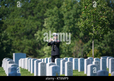 A bugler from The U.S. Navy Band participates in the graveside service for U.S. Navy Fireman 1st Class Walter B. Rogers at Arlington National Cemetery, Arlington, Va., Oct. 2, 2017.  Rogers perished on the USS Oklahoma when it was attacked by Japanese aircraft at Ford Island, Pearl Harbor on Dec. 7, 1941.  Remains of the deceased crew were recovered from December 1941 to June 1944 and were subsequently interred in the Halawa and Nu’uanu Cemeteries.  In September 1947, the remains were disinterred and 35 men from the USS Oklahoma were identified by the American Graves Registration Service (AGRS Stock Photo